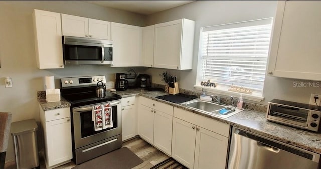 2729 Club Cortile Cir, Kissimmee, FL 34746 - kitchen with appliances with stainless steel finishes, a sink, and white cabinetry