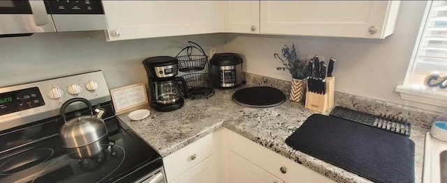 2729 Club Cortile Cir, Kissimmee, FL 34746 - kitchen view of appliances with stainless steel finishes, white cabinetry, light stone counters, and extractor fan