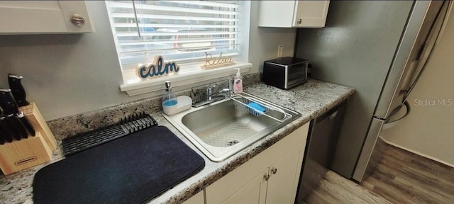 2729 Club Cortile Cir, Kissimmee, FL 34746 - kitchen featuring a sink, wood finished floors, white cabinetry, and light countertops