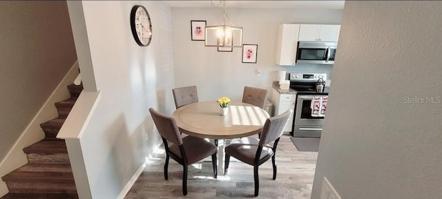 2729 Club Cortile Cir, Kissimmee, FL 34746 - dining room featuring light wood-style flooring, stairs, and baseboards