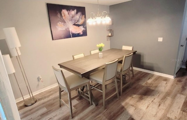 2729 Club Cortile Cir, Kissimmee, FL 34746 - dining room featuring wood finished floors, baseboards, and a chandelier