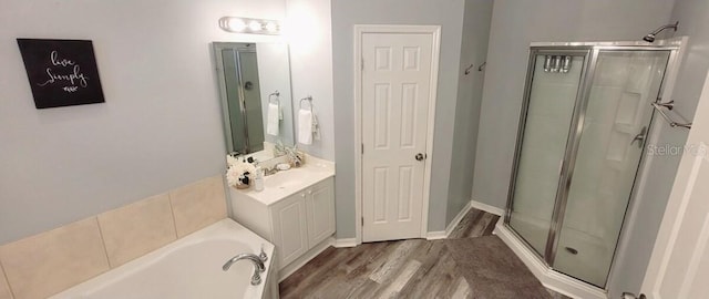 2729 Club Cortile Cir, Kissimmee, FL 34746 - bathroom with a shower stall, wood finished floors, a garden tub, and vanity