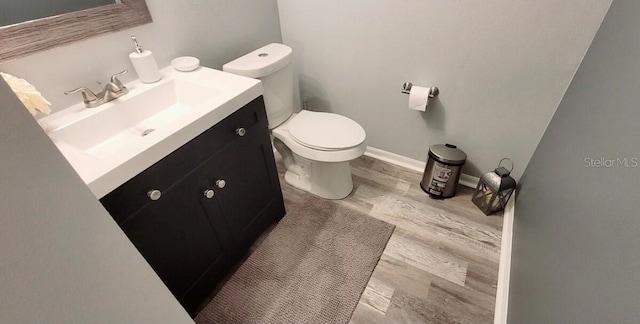 2729 Club Cortile Cir, Kissimmee, FL 34746 - half bathroom featuring toilet, vanity, and wood finished floors