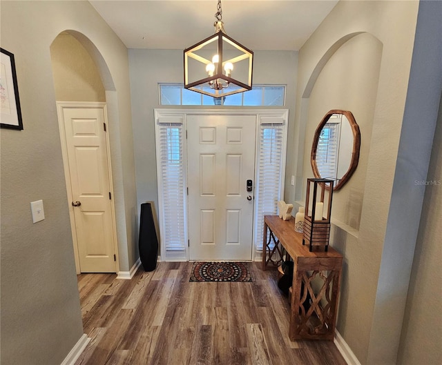 2531 Old Kent Cir, Kissimmee, FL 34758 - entryway with wood finished floors, arched walkways, baseboards, and a chandelier