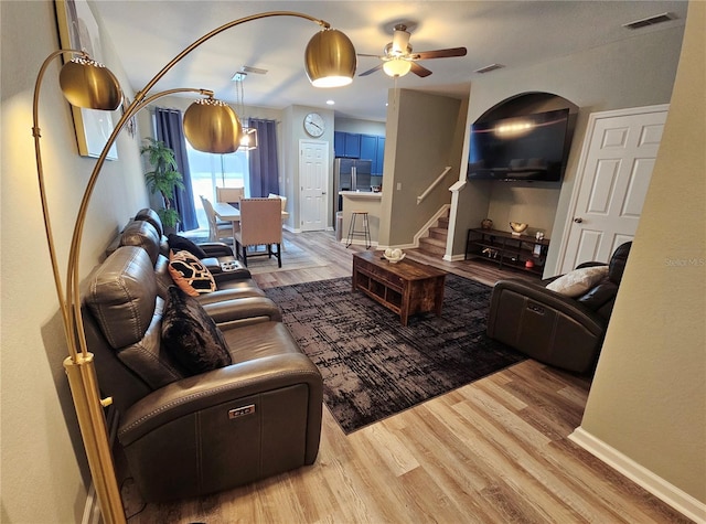 2531 Old Kent Cir, Kissimmee, FL 34758 - living area featuring light wood-style flooring, a ceiling fan, stairway, and baseboards