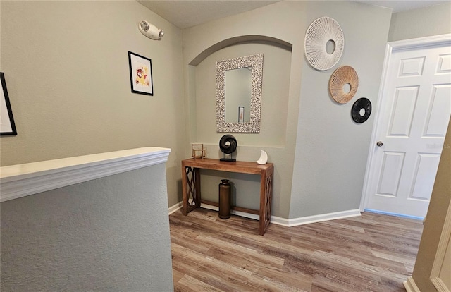 2531 Old Kent Cir, Kissimmee, FL 34758 - hallway featuring wood finished floors, arched walkways, and baseboards