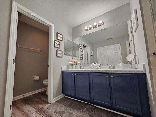 2531 Old Kent Cir, Kissimmee, FL 34758 - full bath with wood finished floors, toilet, double vanity, and baseboards