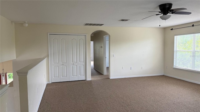 979 Hacienda Cir, Kissimmee, FL 34741 - carpeted empty room with arched walkways, ceiling fan, and baseboards
