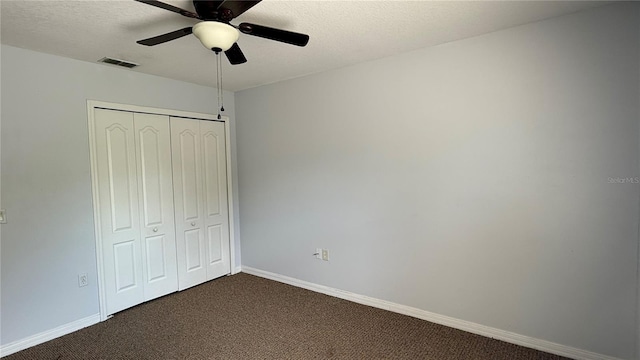 979 Hacienda Cir, Kissimmee, FL 34741 - unfurnished bedroom featuring dark carpet, a closet, baseboards, a textured ceiling, and ceiling fan