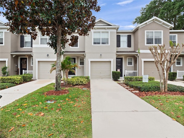 view of property featuring stucco siding, a garage, and driveway