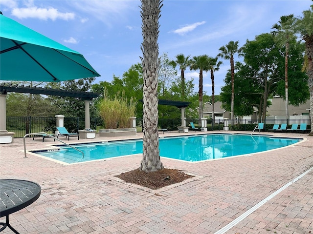 community pool featuring fence and a patio