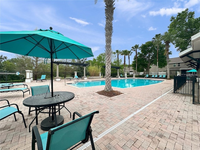 community pool featuring fence and a patio area