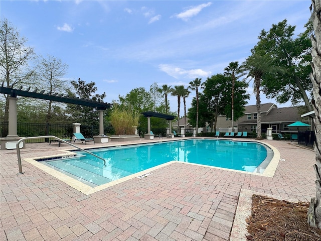community pool with a patio area and fence