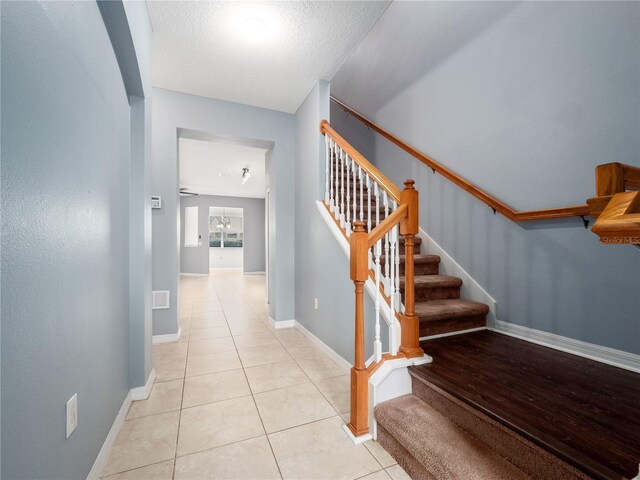 staircase with tile patterned floors and baseboards
