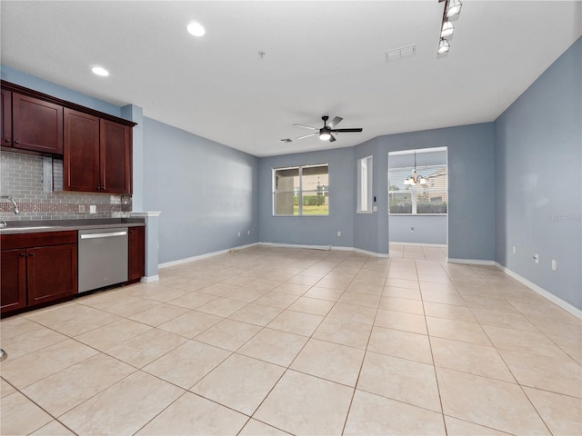 kitchen with stainless steel dishwasher, ceiling fan, backsplash, a sink, and baseboards