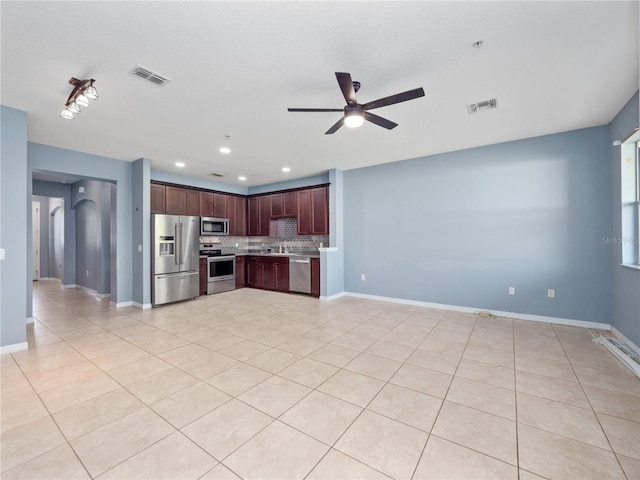 kitchen featuring appliances with stainless steel finishes, a ceiling fan, backsplash, light countertops, and light tile patterned floors