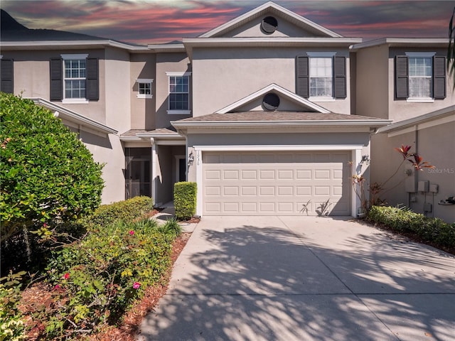 view of front of home featuring concrete driveway, a garage, and stucco siding