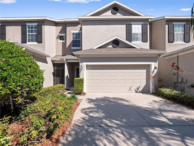 multi unit property featuring concrete driveway, a garage, and stucco siding