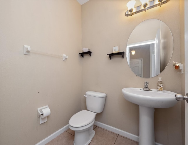 bathroom featuring toilet, tile patterned flooring, and baseboards