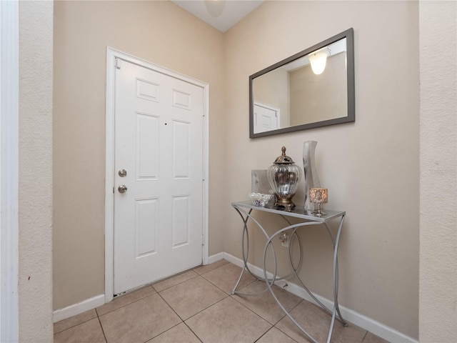 foyer entrance with baseboards and light tile patterned floors