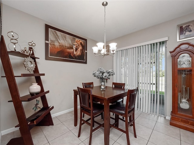 dining area with a chandelier, light tile patterned floors, and baseboards