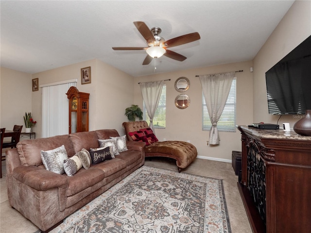living area featuring ceiling fan, carpet floors, and baseboards