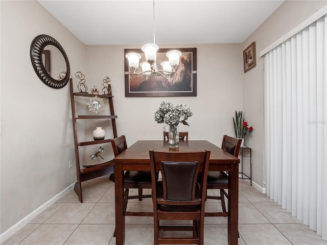 dining space featuring light tile patterned floors, a chandelier, and baseboards