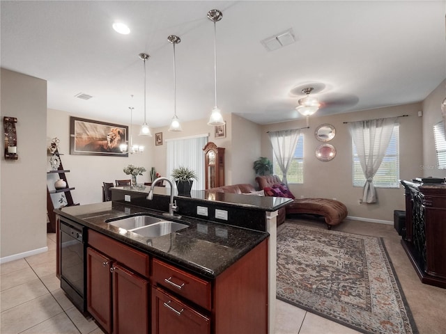 kitchen featuring a sink, black dishwasher, open floor plan, a center island with sink, and dark stone countertops
