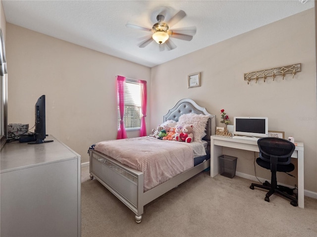 bedroom with light carpet, a desk, baseboards, and ceiling fan