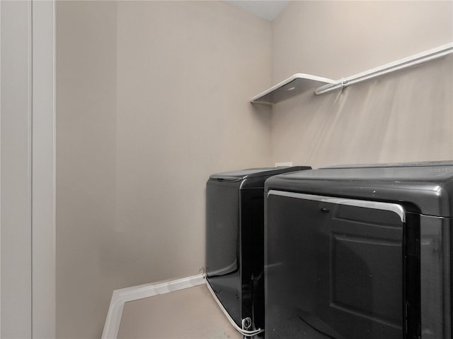 laundry room with washer and dryer and baseboards