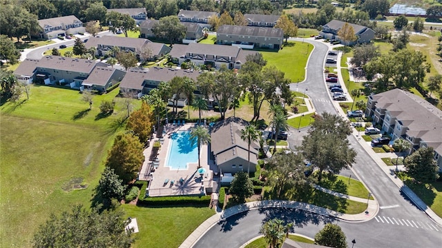 aerial view of property's location with a pool area and nearby suburban area