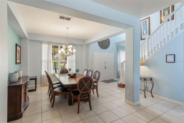8571 La Isla Dr, Kissimmee, FL 34747 - dining room with healthy amount of natural light, a chandelier, stairway, and light tile patterned floors