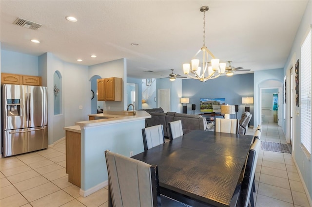8571 La Isla Dr, Kissimmee, FL 34747 - dining space featuring arched walkways, ceiling fan, a chandelier, light tile patterned flooring, and recessed lighting