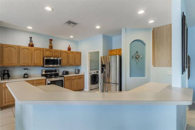 8571 La Isla Dr, Kissimmee, FL 34747 - kitchen with appliances with stainless steel finishes, washer / clothes dryer, recessed lighting, and light countertops