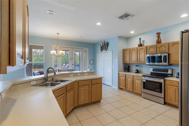 8571 La Isla Dr, Kissimmee, FL 34747 - kitchen featuring appliances with stainless steel finishes, light countertops, decorative light fixtures, a chandelier, and recessed lighting