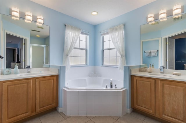 8571 La Isla Dr, Kissimmee, FL 34747 - bathroom with two vanities, a garden tub, tile patterned floors, and a shower stall