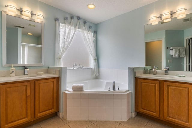 8571 La Isla Dr, Kissimmee, FL 34747 - full bath featuring two vanities, a garden tub, tile patterned floors, and a stall shower