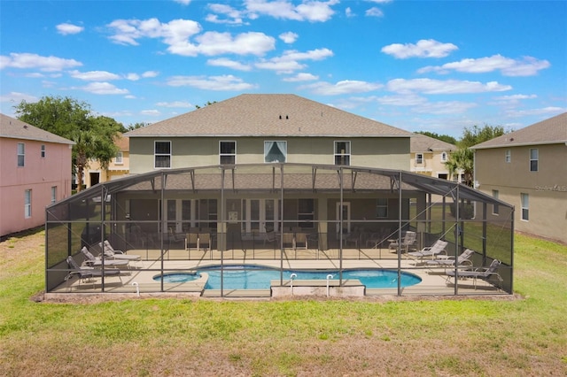 8571 La Isla Dr, Kissimmee, FL 34747 - view of pool with a patio area, a lawn, glass enclosure, and a pool with connected hot tub