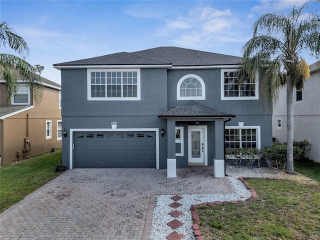 5768 Los Palma Vista Dr, Orlando, FL 32837 - traditional home with decorative driveway, a garage, stucco siding, a shingled roof, and a front lawn