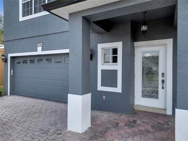 5768 Los Palma Vista Dr, Orlando, FL 32837 - view of exterior entry with an attached garage, driveway, and stucco siding
