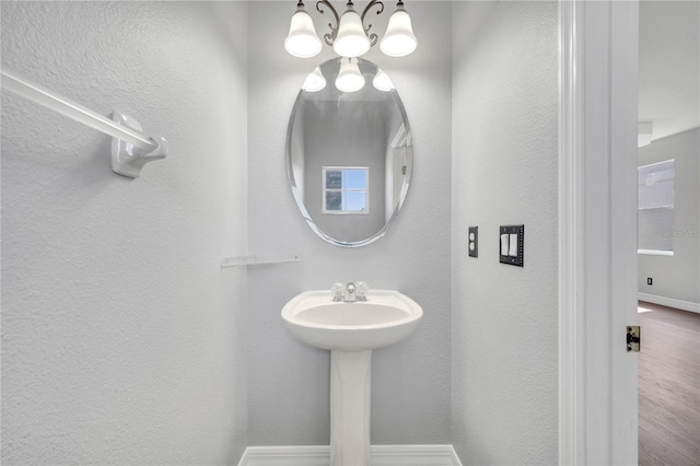 5768 Los Palma Vista Dr, Orlando, FL 32837 - bathroom featuring a chandelier, baseboards, wood finished floors, and a textured wall