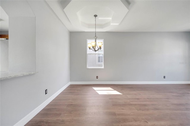 5768 Los Palma Vista Dr, Orlando, FL 32837 - empty room with a chandelier, wood finished floors, a raised ceiling, and baseboards