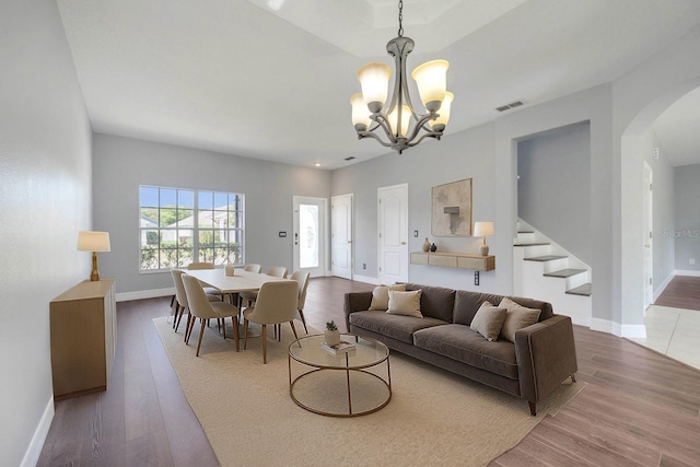 5768 Los Palma Vista Dr, Orlando, FL 32837 - living area featuring arched walkways, a chandelier, wood finished floors, baseboards, and stairs