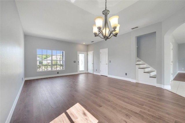 5768 Los Palma Vista Dr, Orlando, FL 32837 - unfurnished living room featuring a chandelier, arched walkways, wood finished floors, and stairs