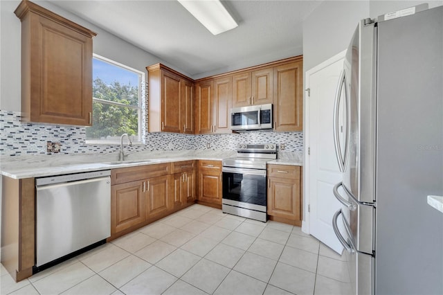 5768 Los Palma Vista Dr, Orlando, FL 32837 - kitchen with appliances with stainless steel finishes, a sink, backsplash, and brown cabinets