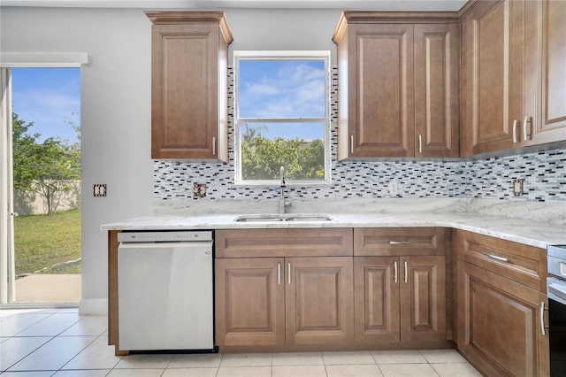 5768 Los Palma Vista Dr, Orlando, FL 32837 - kitchen with stainless steel dishwasher, a sink, backsplash, light stone countertops, and light tile patterned flooring