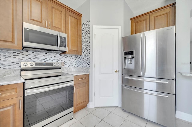 5768 Los Palma Vista Dr, Orlando, FL 32837 - kitchen with appliances with stainless steel finishes, tasteful backsplash, light tile patterned floors, and brown cabinets