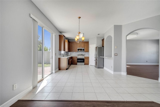 5768 Los Palma Vista Dr, Orlando, FL 32837 - kitchen with stainless steel appliances, light countertops, arched walkways, a sink, and a chandelier