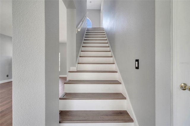 5768 Los Palma Vista Dr, Orlando, FL 32837 - staircase with a textured wall, baseboards, and wood finished floors