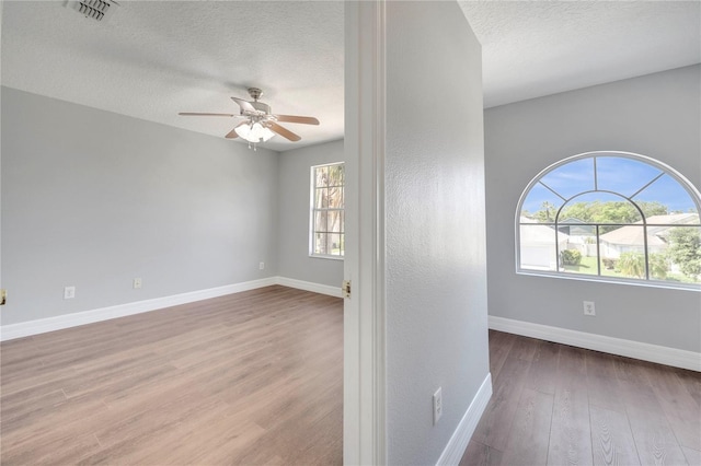 5768 Los Palma Vista Dr, Orlando, FL 32837 - empty room with wood finished floors, ceiling fan, baseboards, and a textured ceiling